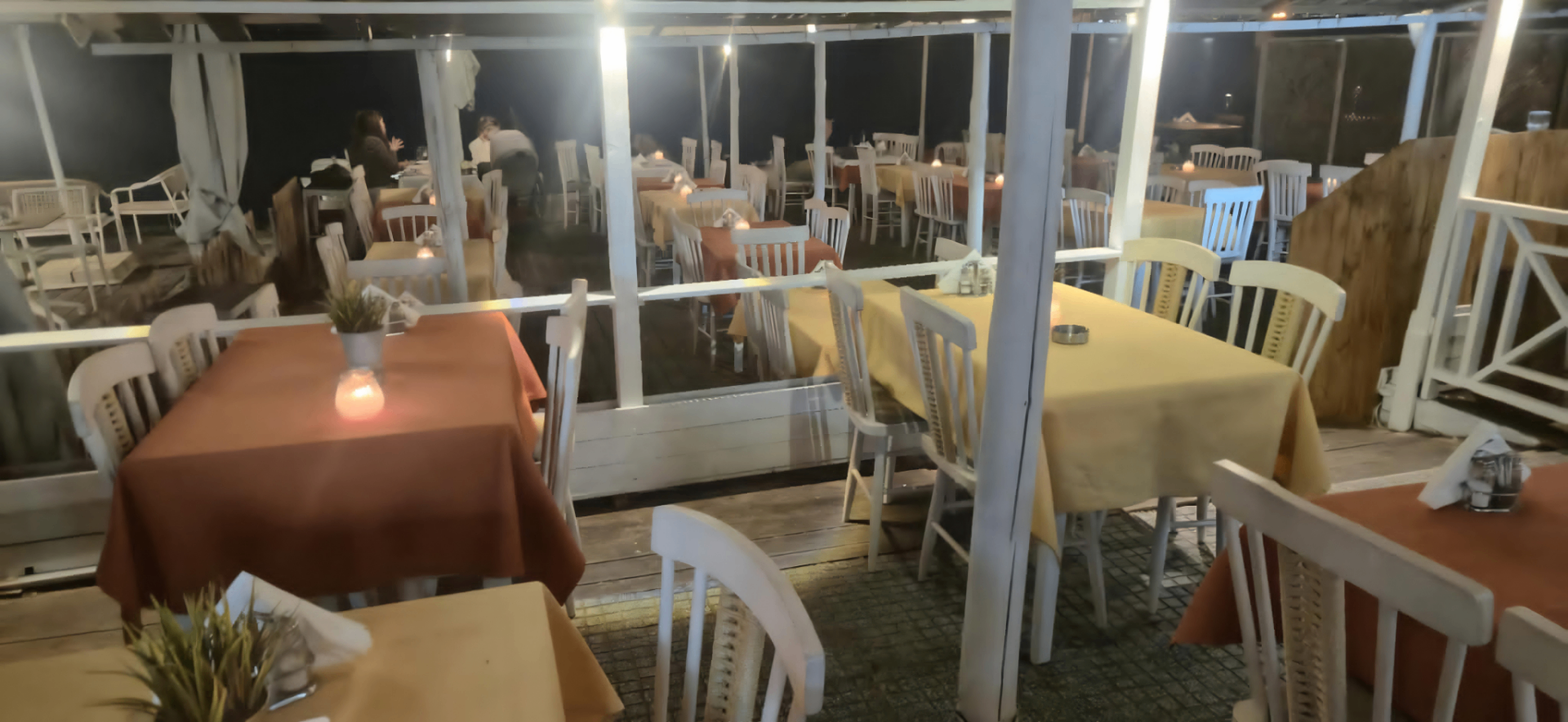 Restaurant tables with candles by the sea